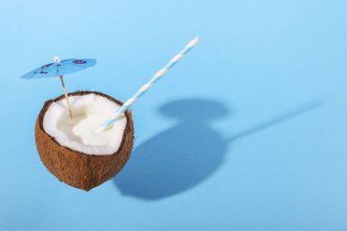 Hindistan cevizi bir kabuk bir şemsiye ve saman ile Kupası'nda kokteyl. Tropikal tatil, yaz ruh hali, kopya alanı kavramı.