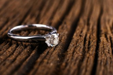 Beyaz altın ve platin elmas nişan yüzüğü. Tahta masada. Düğün, Sevgililer günü için bir hediye olarak teklif.