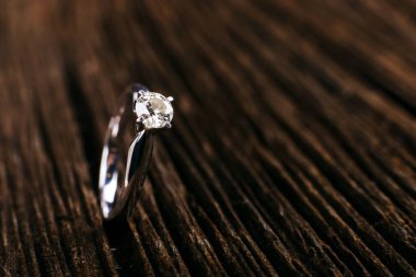 Beyaz altın ve platin elmas nişan yüzüğü. Tahta masada. Düğün, Sevgililer günü için bir hediye olarak teklif.