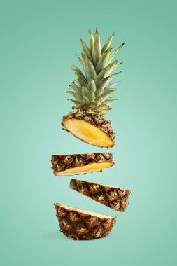 Ananas dilimlenmiş, havada levitates. Yeşil bir arka planda yaz ruh kavramı.
