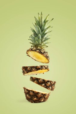 Ananas dilimlenmiş, havada levitates. Yeşil bir arka planda yaz ruh kavramı.