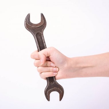 Bir kızın elinde bir anahtar. Sert çalışma sembolü, feminizm ve işgücü günü. Beyaz arka planda izole et.