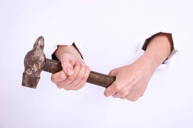 Bir kızın elinde çekiç var. Sert çalışma sembolü, feminizm ve işgücü günü. Beyaz arka planda izole et.