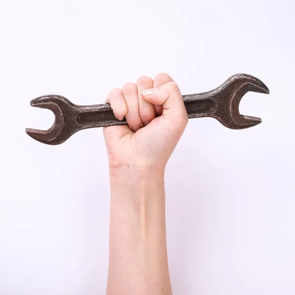 Une clé dans la main d'une fille. Symbole de travail acharné, féminisme et journée du travail. Isoler sur fond blanc . — Photo