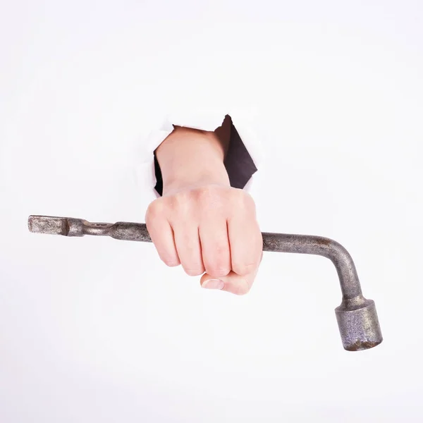 Clé à molette dans la main de la fille. Symbole de travail acharné, féminisme et journée du travail. Isoler sur fond blanc . — Photo