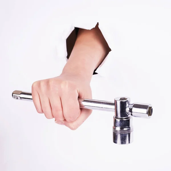 Stacked wrench in the hand of a girl. Symbol of hard work, feminism and labor day. Isolate on white background.