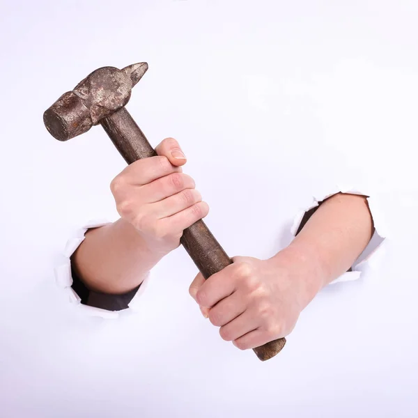 Marteau dans la main d'une fille. Symbole de travail acharné, féminisme et journée du travail. Isoler sur fond blanc . — Photo