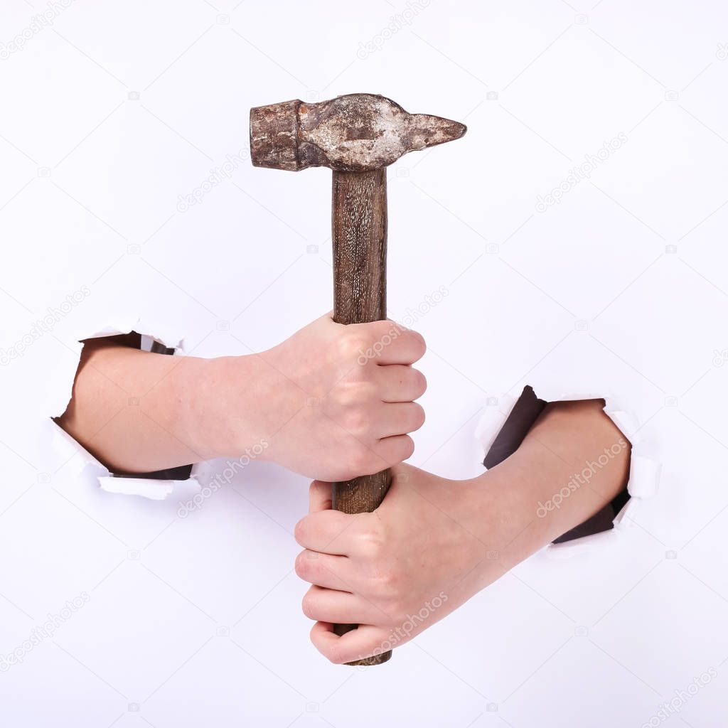 Hammer in the hand of a girl. Symbol of hard work, feminism and labor day. Isolate on white background.