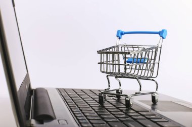 Alışveriş sepeti dizüstü bilgisayar üzerinde. Online satış konsepti.