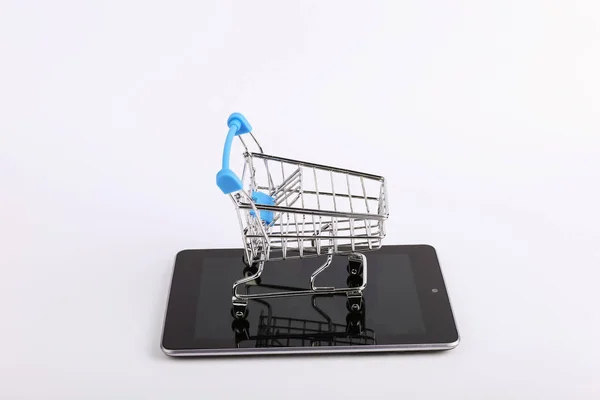 Shopping cart stands on the smartphone. Online sales concept. — Stock Photo, Image