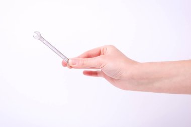 Bir kızın elinde bir anahtar. Sert çalışma sembolü, feminizm ve işgücü günü. Beyaz arka planda izole et.