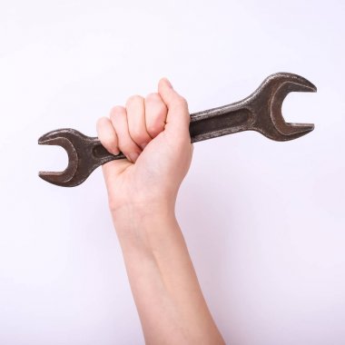 Bir kızın elinde bir anahtar. Sert çalışma sembolü, feminizm ve işgücü günü. Beyaz arka planda izole et.