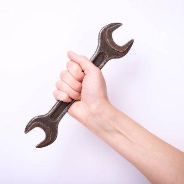 Bir kızın elinde bir anahtar. Sert çalışma sembolü, feminizm ve işgücü günü. Beyaz arka planda izole et.