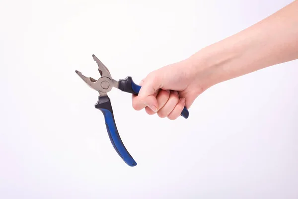 Pinces dans la main d'une fille. Symbole de travail acharné, féminisme et journée du travail. Isoler sur fond blanc . — Photo