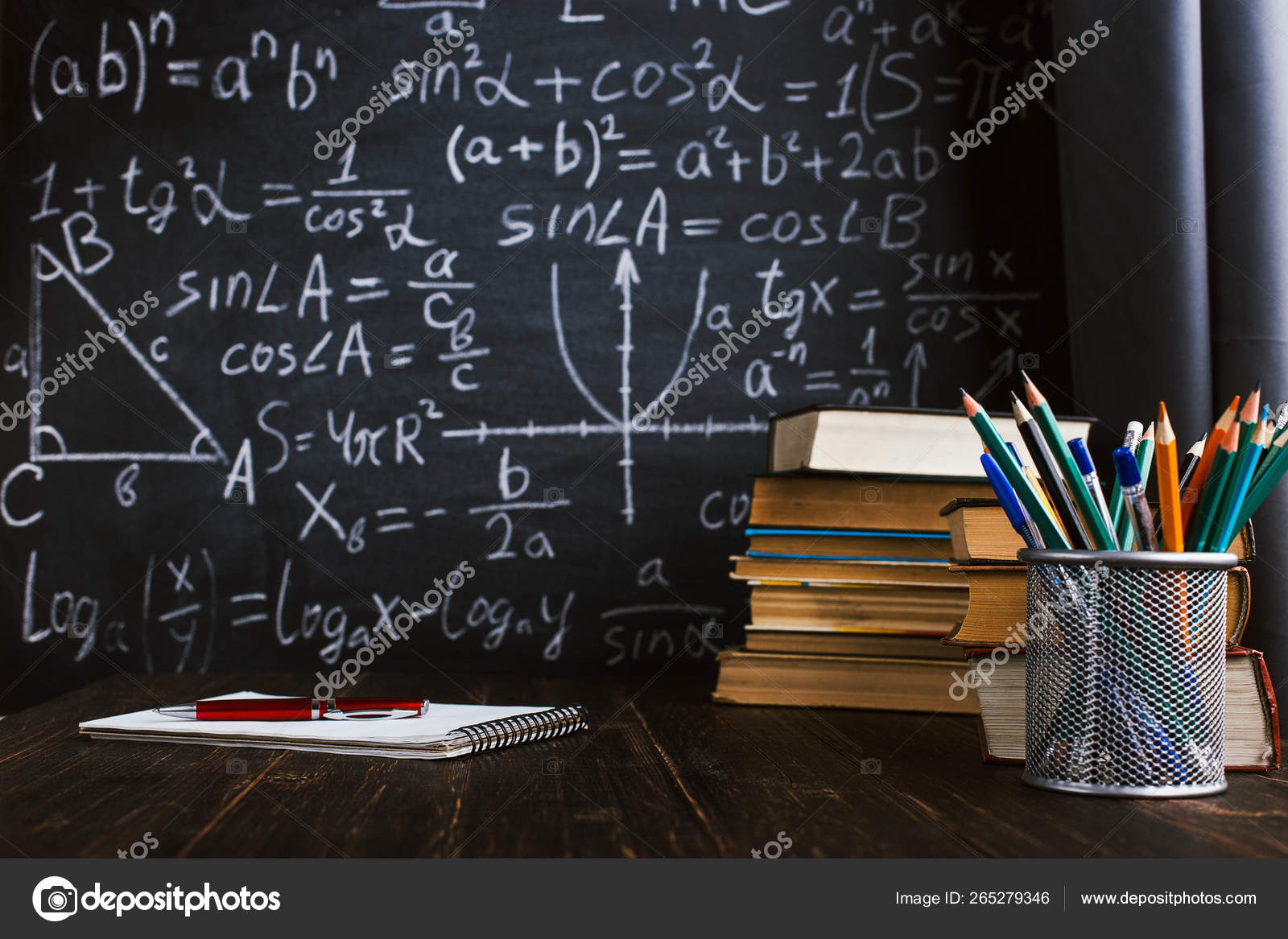 School Desk In Classroom With Books On Background Of Chalk Board