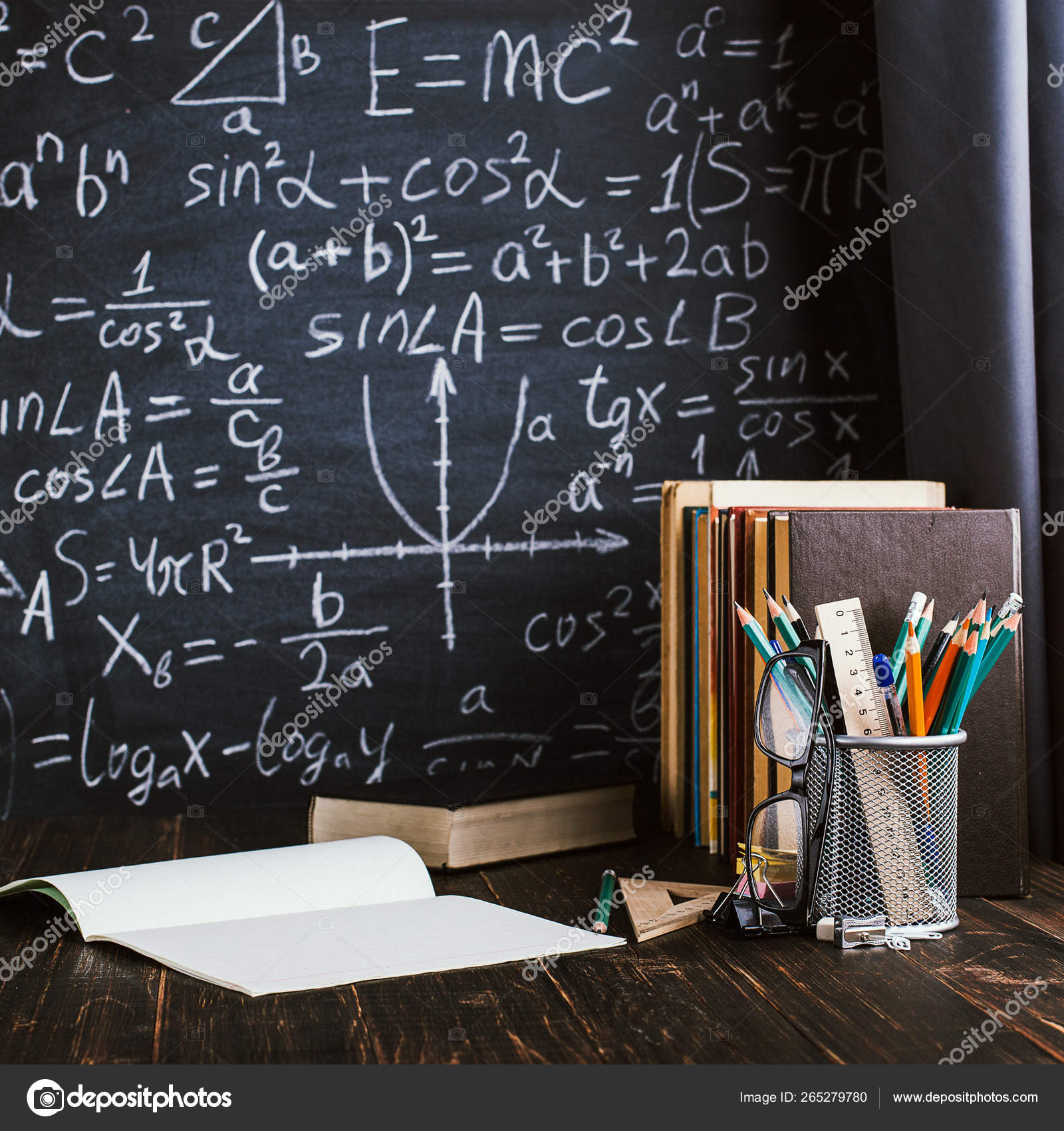 School Desk In Classroom With Books On Background Of Chalk Board