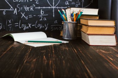 Sınıf içinde okul sırası, yazılı formüller ile tebeşir tahtası arka plan üzerinde kitaplar ile. Soncept Öğretmenler Günü. Spase kopyala.