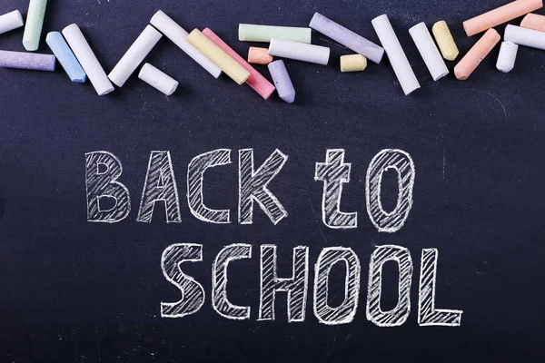 Crayones multicolores yacen en una pizarra negra, espacio para copiar. El concepto de escuela, educación e infancia . —  Fotos de Stock