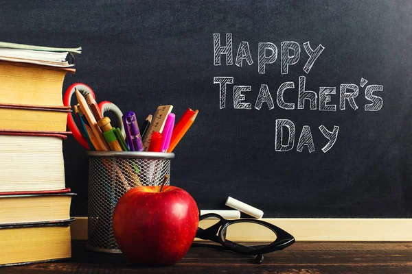 Escritorio del profesor con materiales de escritura, un libro y una manzana, un espacio en blanco para el texto o un fondo para un tema escolar. Copiar espacio . — Foto de Stock