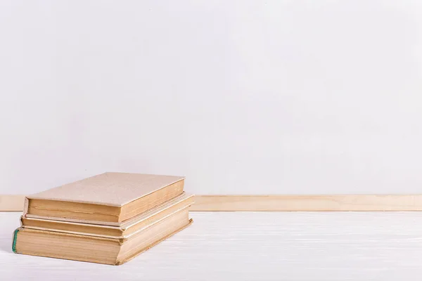 Livros na mesa contra o fundo de uma tábua branca. Espaço de cópia . — Fotografia de Stock