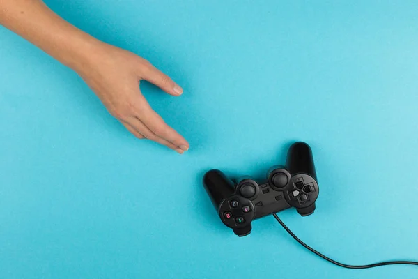 Frauenhände halten ein Gamepad auf blauem Hintergrund. Wochenendkonzept, Gaming-Hobby. Kopierraum. — Stockfoto