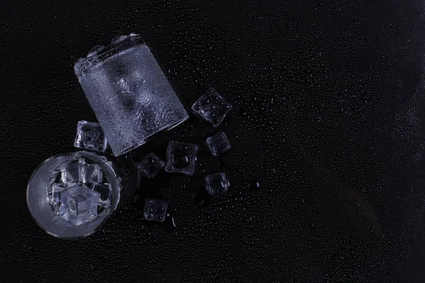 A foggy inverted glass and ice lie on a black background, cold condensate. — Stock Photo, Image