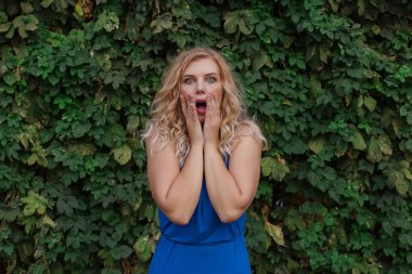 Vahşi üzüm bir duvar arka planda korkmuş genç güzel kız. Kopyalama alanı.