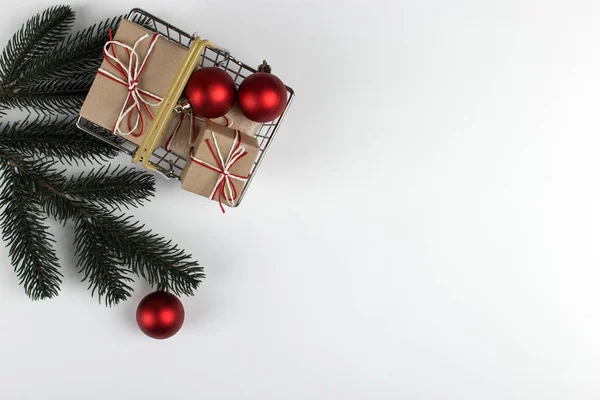Regalos en una pequeña cesta de la compra sobre un fondo blanco con decoraciones de Navidad, concepto, espacio de copia . — Foto de Stock