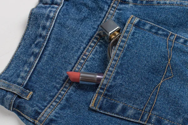 Profumo e rossetto in una tasca di blue jeans . — Foto Stock