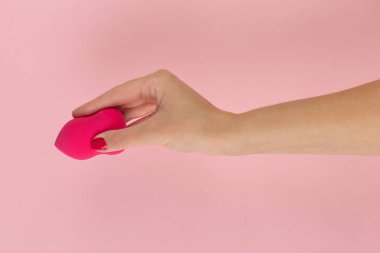 Kız el pembe bir arka plan üzerinde bir güzellik makyaj blender tutar, kopya alanı.