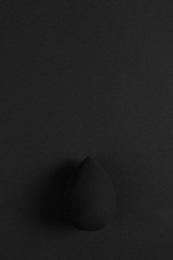 Siyah sünger, güzel bir blender, siyah bir arka plan üzerinde yatıyor. Tasarım, makyaj sanatçısı kavramı kopyalama alanı.