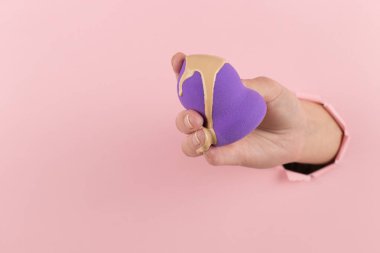 Kız el temel bir güzellik blender tutar, pembe bir arka plan bir delik kapatıcı. Makyaj sanatçısı kavramı, kopyalama alanı.