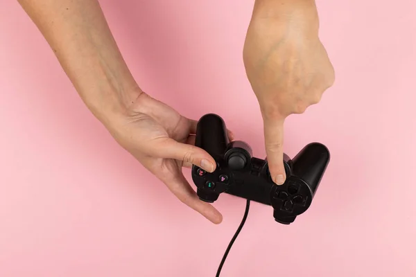 As mãos femininas mantêm um gamepad em um fundo rosa. Conceito de fim-de-semana, passatempo. Espaço de cópia . — Fotografia de Stock