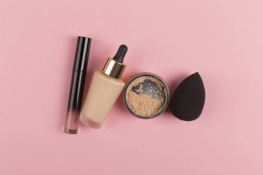 Süngerler, vakıf veya toz ve kapatıcı bir şişe uygulamak için güzel bir blender. Düz pembe bir arka plan üzerinde yatıyordu, kopyalama alanı.