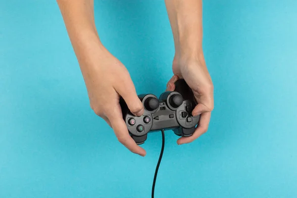 Женские руки держат геймпад на синем фоне. Концепция выходных, игровое хобби. Копирование пространства . — стоковое фото