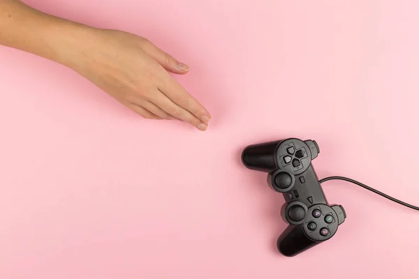 Женские руки держат геймпад на розовом фоне. Концепция выходных, игровое хобби. Копирование пространства . — стоковое фото