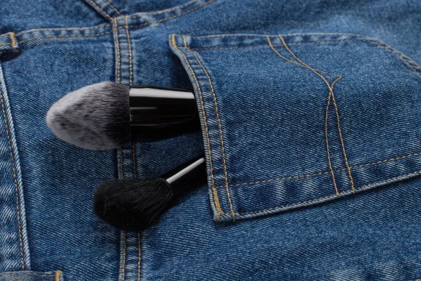 Grandi pennelli per il trucco in una tasca di jeans blu. Concetto, lavoro commerciale di un truccatore, per stampare biglietti da visita e brochure . — Foto Stock