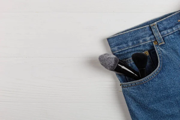 Grandi pennelli per il trucco in una tasca di jeans blu. Concetto, lavoro commerciale di un truccatore, per stampare biglietti da visita e brochure . — Foto Stock