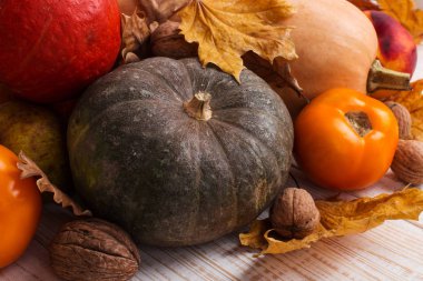 Farklı sebzeler, kabaklar, elma, armut, fındık, domates ve kuru yaprakları beyaz ahşap arka plan üzerinde. Sonbahar havası, kopya alanı. Hasat konsepti.