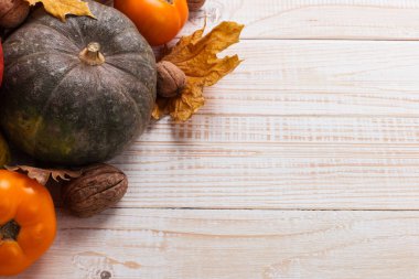 Farklı sebzeler, kabaklar, elma, armut, fındık, domates ve kuru yaprakları beyaz ahşap arka plan üzerinde. Sonbahar havası, kopya alanı. Hasat konsepti.