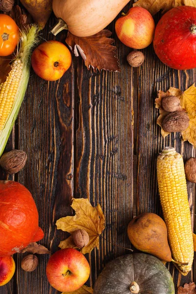 Különböző zöldségek, sütőtök, alma, körte, dió, paradicsom, kukorica, száraz sárga levelek a fából készült háttér. Őszi hangulat, másolás tér. Szüreti koncepció. — Stock Fotó
