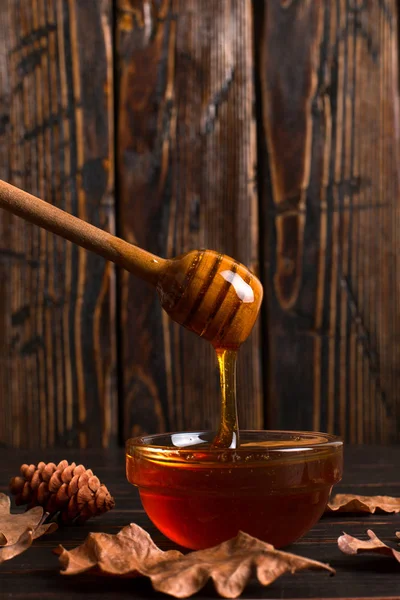 O mel flui de um pau para um frasco. Rústico doce outono foto , — Fotografia de Stock