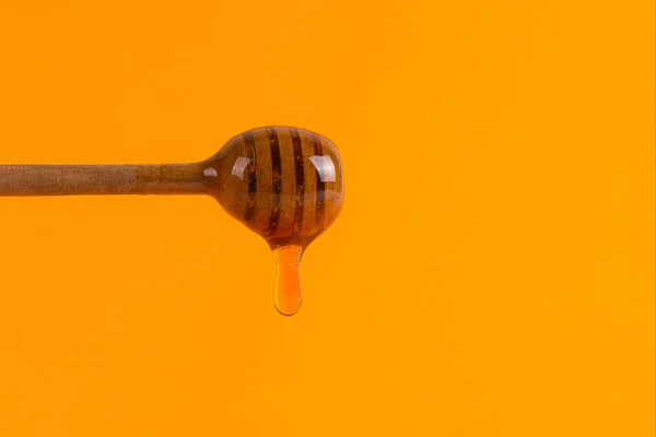 Un palo para la miel y un frasco pequeño, concepto sobre un fondo amarillo —  Fotos de Stock