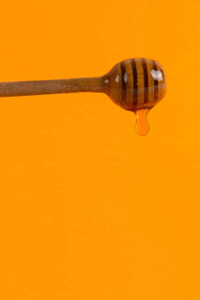 Um pau de mel e um pequeno jarro, conceito em um backgroun amarelo — Fotografia de Stock