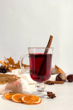 Masada baharat, atkı, baharat, kuru yaprak ve portakal ile mulled şarap bir fincan. Sonbahar ruh hali, soğukta sıcak tutmak için bir yöntem, kopya alanı.