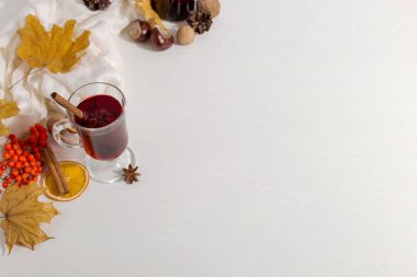 Masada baharat, şişe, atkı, baharat, kuru yaprak ve portakal ile mulled şarap bir fincan. Sonbahar ruh hali, soğuk sıcak tutmak için yöntem, kopya alanı.