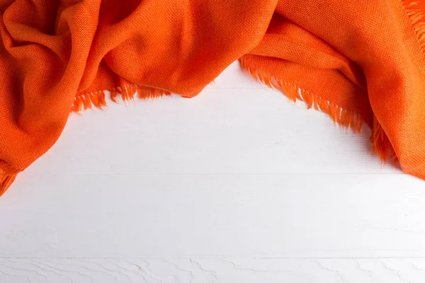 Chal cálido naranja brillante, sobre un fondo blanco, humor otoñal, espacio para copiar . — Foto de Stock