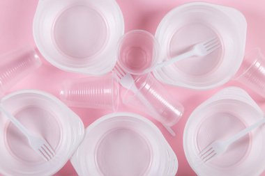 Pembe arka planda plastik kaplar. Çevresel değil, kirlilik.