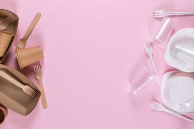 Pembe arka planda plastik ve kağıt çatal bıçaklar. Çevre dostu aletler seçmek, ekolojik felaketlerle savaşmak..