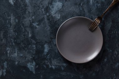 Koyu beton arka planda gri boş bir plaka, tasarım için boş..